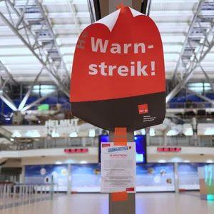 Ein Plakat mit dem Text „Warnstreik!“ hängt im menschenleeren Terminal 2 im Flughafen Hamburg.