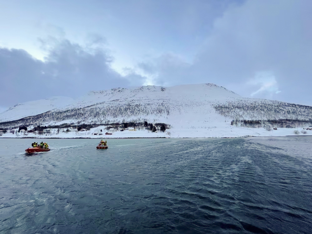 Rettungshelfer sind nach einer Schneelawine auf der Insel Reinoya mit Booten im Einsatz.