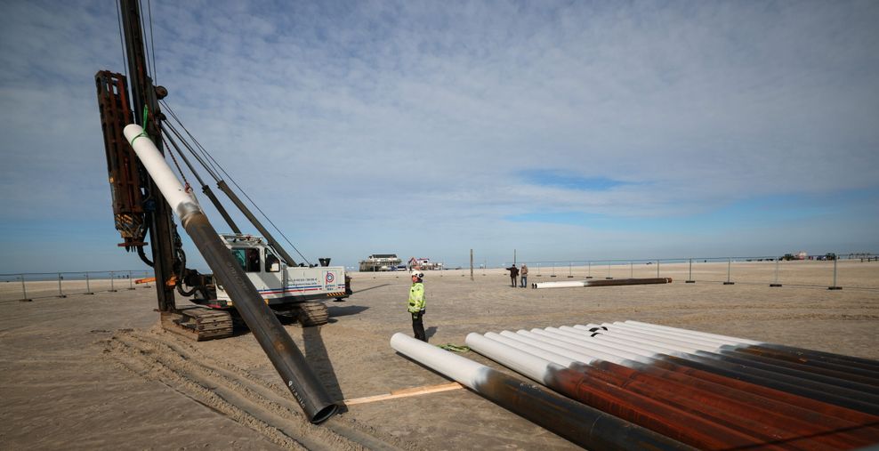 Arbeiter beim setzen der Ersten Stahlpfähle auf einer Baustelle am Ordinger Strand.
