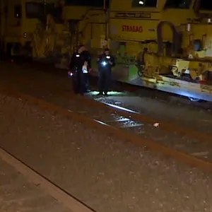 Einsatzkräfte der Polizei untersuchen an eine Unfallstelle neben einem Zug die Bahngleise. Ein 13-Jähriger ist an einem Bahnhof in Langenhagen nördlich von Hannover auf einen Bahnwaggon geklettert und durch einen Stromschlag schwer verletzt worden.