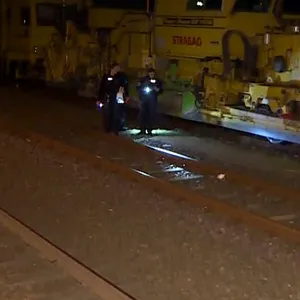 Einsatzkräfte der Polizei untersuchen an eine Unfallstelle neben einem Zug die Bahngleise. Ein 13-Jähriger ist an einem Bahnhof in Langenhagen nördlich von Hannover auf einen Bahnwaggon geklettert und durch einen Stromschlag schwer verletzt worden.