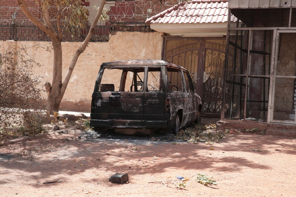 Ein zerstörtes Militärfahrzeug steht während anhaltender Kämpfe in der Stadt vor einem Haus.