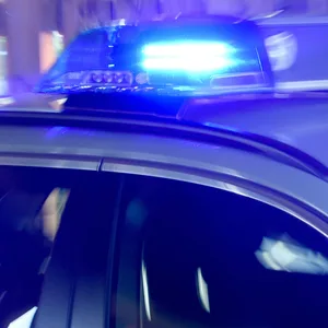 Ein Streifenwagen mit eingeschaltetem Blaulicht.