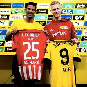 Sebastien Haller und Timo Baumgartl halten das Trikot des jeweils anderen hoch