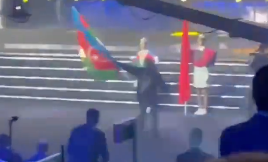 Ein Mann zündet die Flagge Aserbaidschans bei der EM im Gewichtheben in Yerevan an