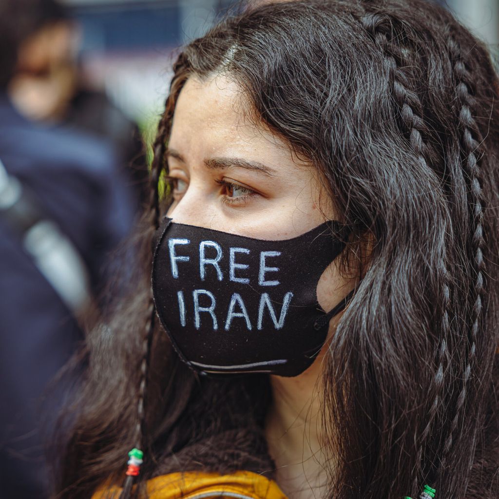 Eine Frau demonstriert vor dem Gericht für einen freien Iran.