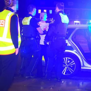Polizeikräfte nehmen einen Mann in Gewahrsam.