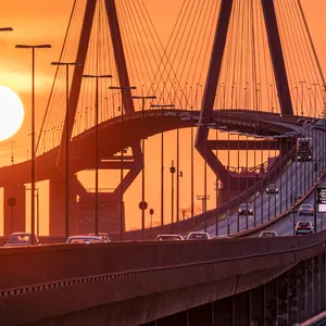 Die Köhlbrandbrücke im Sonnenuntergang. Sie soll abgerissen werden – doch nun wankt die Planung für den neuen Tunnel (Symbolbild).