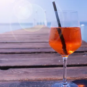 Ein Glas mit Aperol Spritz auf einem Steg