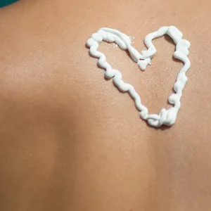 Mann mit Sonnencreme auf dem Rücken.