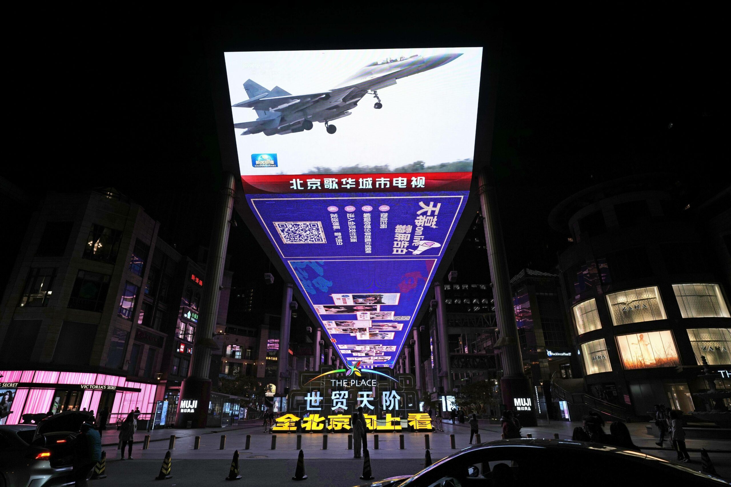 Ein großer Bildschirm auf einer Straße in Peking zeigt ein chinesisches Militärflugzeug, das an einer dreitägigen Luft- und Seeübung um Taiwan teilnimmt.