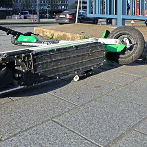 Ein umgekippter E-Scooter liegt auf einer Straße. (Symbolbild)
