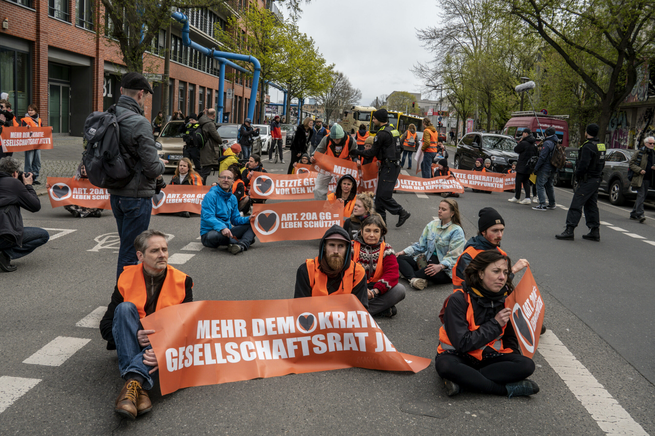 Demonstranten der Letzten Generation blockieren eine Straße in Berlin.