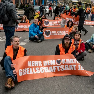 Demonstranten der Letzten Generation blockieren eine Straße in Berlin.