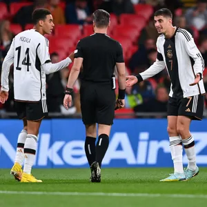 Kai Havertz und Jamal Musiala diskutieren mit dem Schiedsrichter