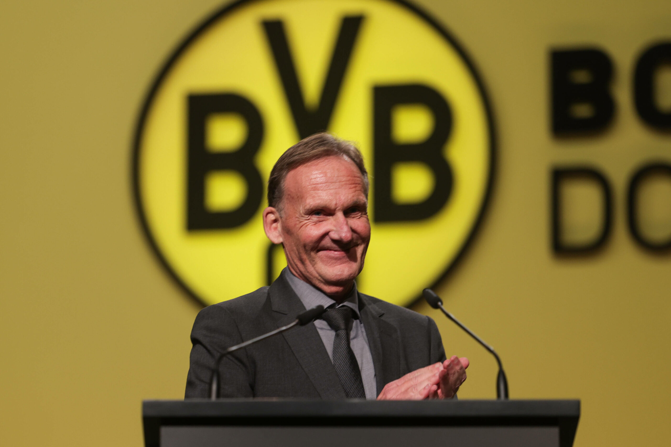 BVB-Boss Hans-Joachim Watzke lächelnd auf einer Dortmunder Pressekonferenz.