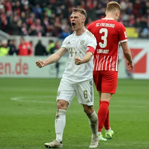 Joshua Kimmich bejubelt den 1:0-Sieg des FC Bayern in Richtung der Freiburger Fankurve