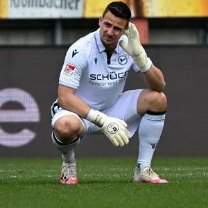 Arminia-Torhüter Martin Fraisl fasst sich nach Detonation des Böllers ans Ohr