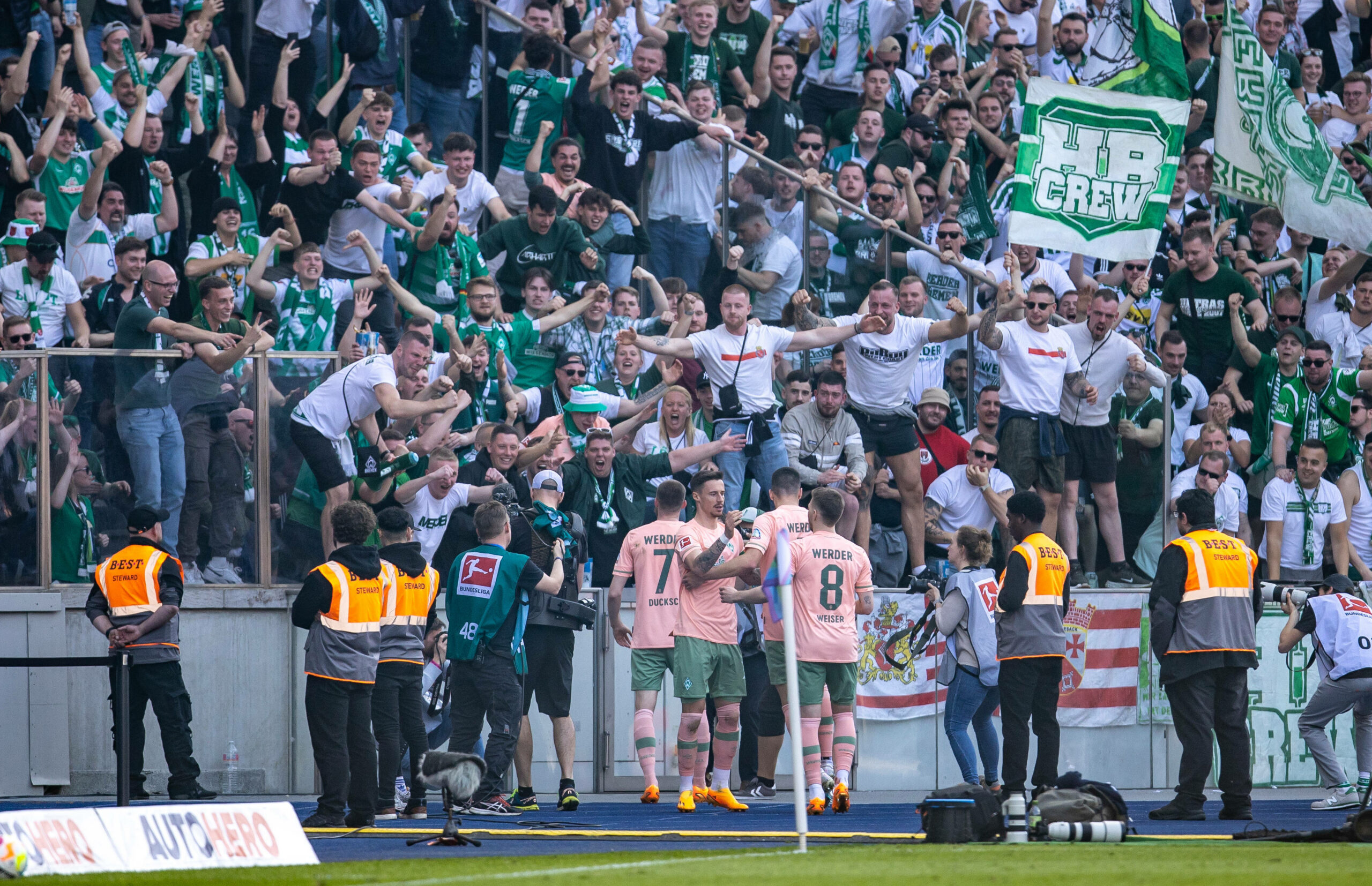 Werder-Profis bejubeln ein Tor gegen Hertha vor dem Gästeblock