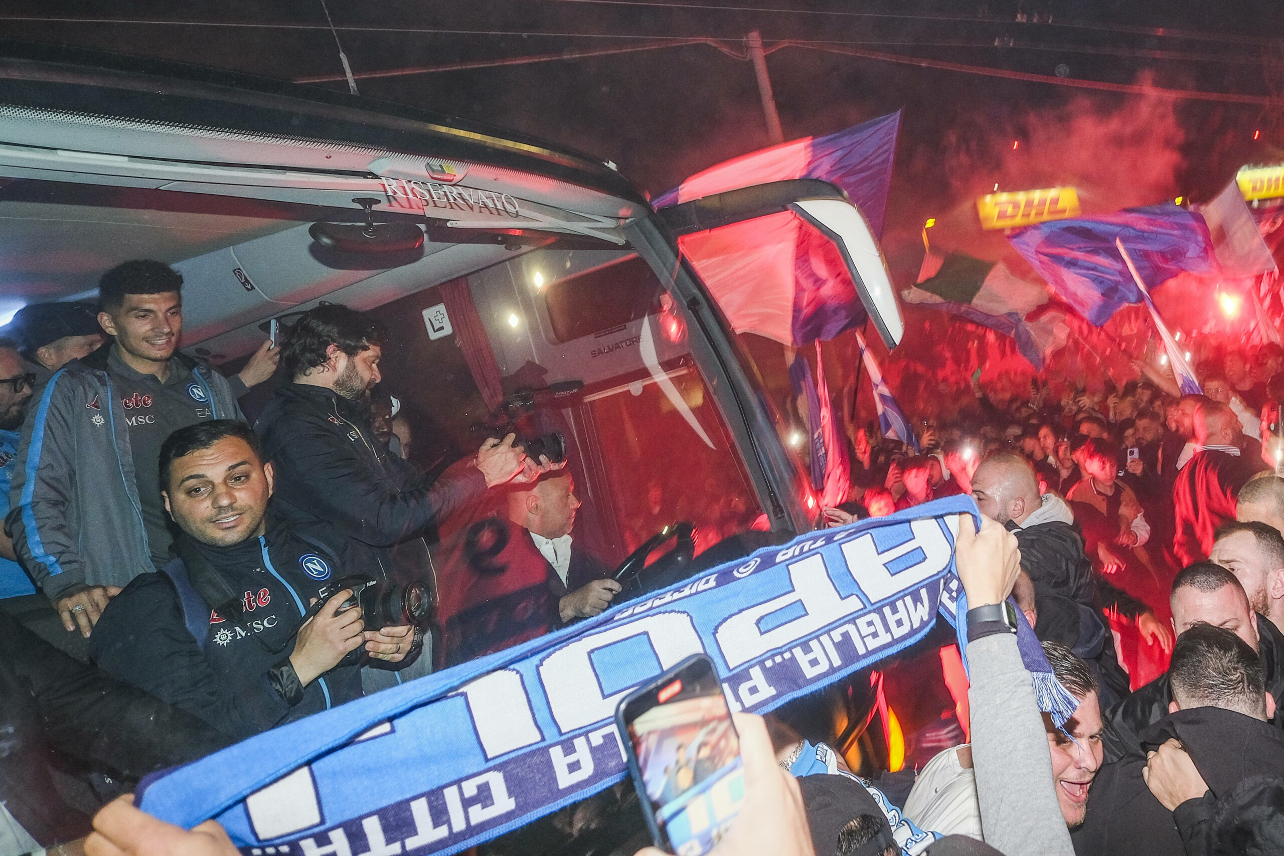 Der Bus vom SSC Neapel umringt von Fans. Im Hintergrund Pyrotechnik-