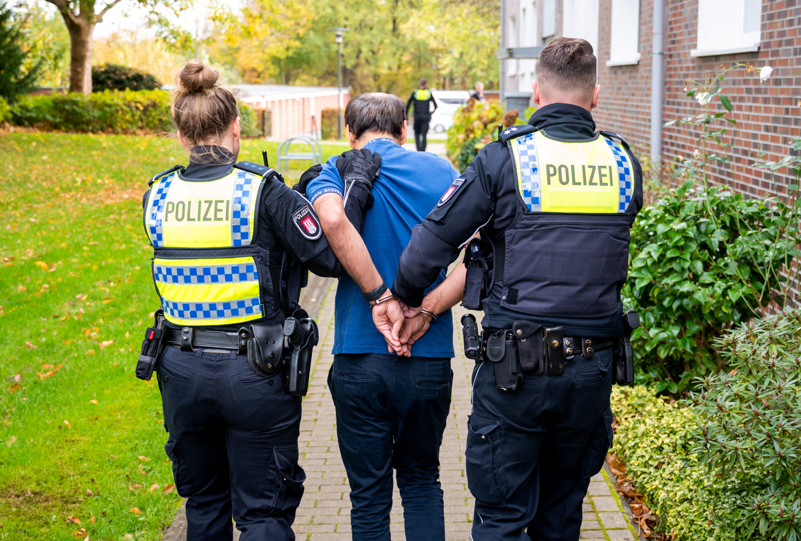 Lohbrügge: Polizisten führen einen Mann ab, der seine Ex-Frau erstochen hat