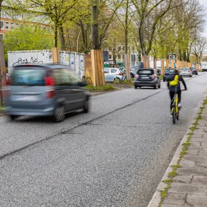 Die Max-Brauer-Allee Richtung Holstenstraße: Auf der linken Fahrspur sind Autos, auf der rechten ein Radfahrer