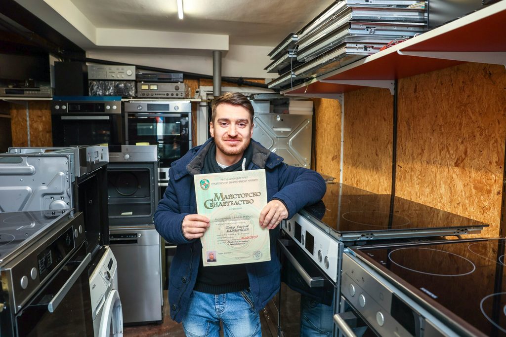 Petko-Petrov Hadzhiyski präsentiert ein bulgarisches Diplom seines Vaters in seinem Laden „Peters Geschäft Haushaltswaren“ in der Seilerstraße 47.