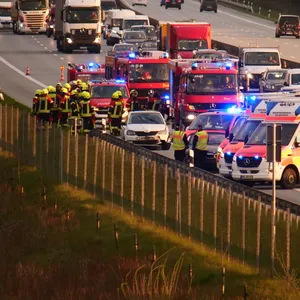 A7: Blick auf die Unfallstelle, mehrere Rettungswagen und Einsatzfahrzeuge der Polizei stehen rund um zwei verunfallte Pkw