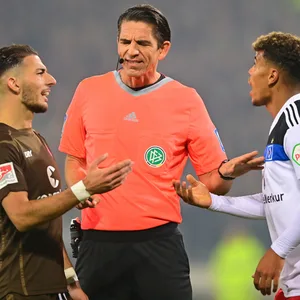 Der Derby-Druck ist spürbar und entlädt sich schon mal in einer Diskussion mit dem Schiedsrichter, wie hier bei St. Paulis Leart Paqarada (l.) und HSV-Angreifer Ransford Königsdörffer mit Referee Deniz Aytekin.