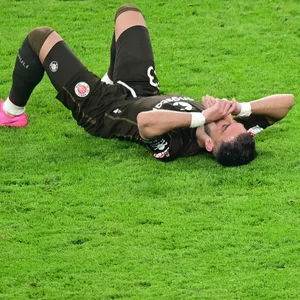 Leart Paqarada vom FC St. Pauli liegt enttäuscht auf dem Rasen