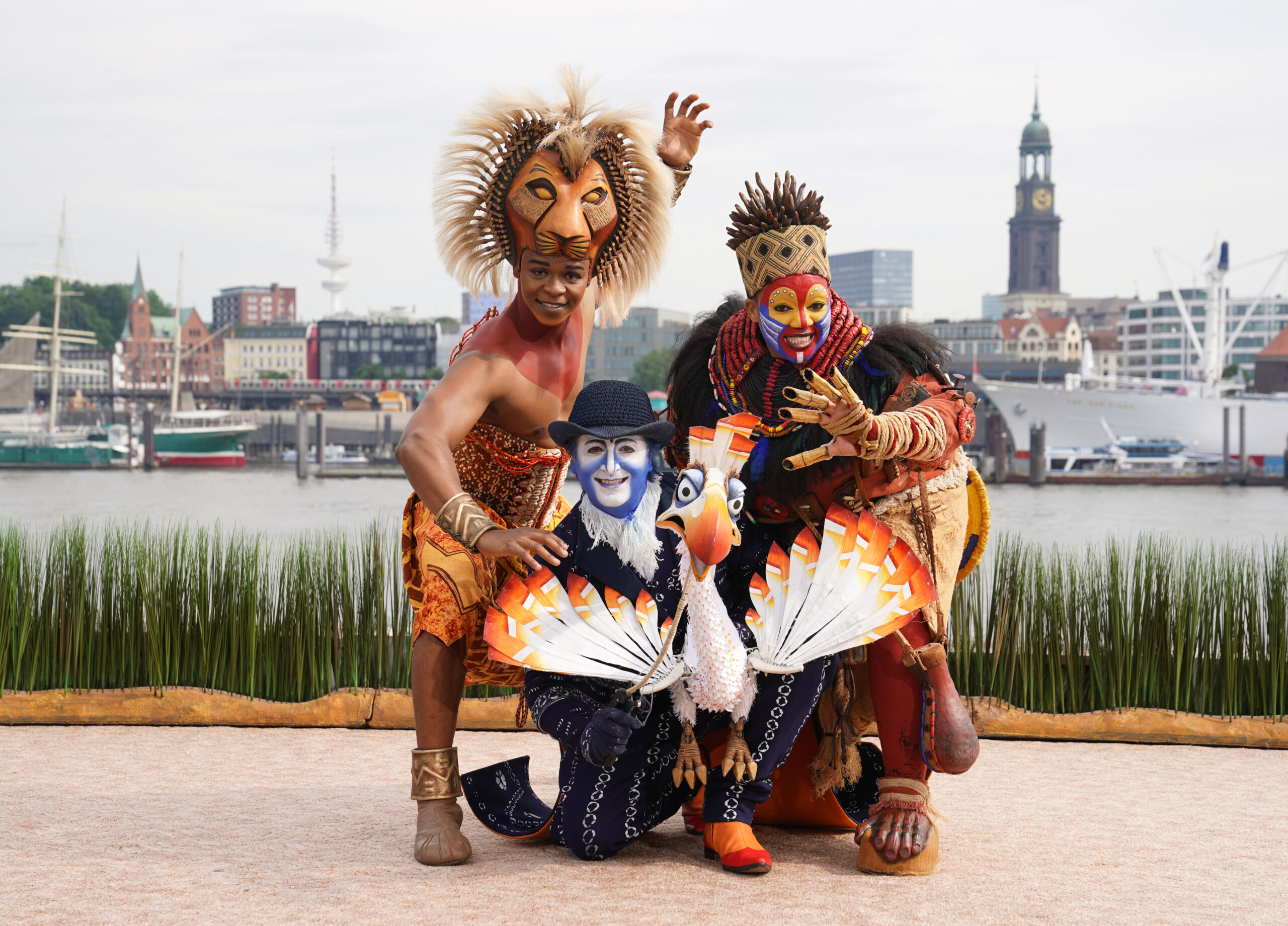 Sie stehen im „König der Löwen“ auf der Bühne: Hope Maine als Simba (v.l.n.r.), Joachim Benoit als Zazu und Thenjiwe Nofemele als Rafiki.