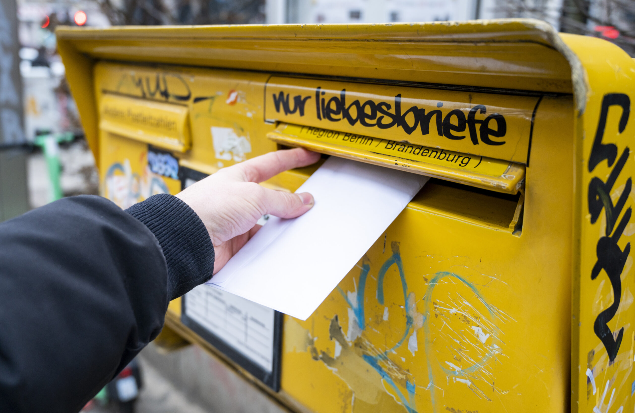 Eine Person wirft einen Brief in einen Briefkasten. Geht's nach der Post, kostet die benötigte Briefmarke bald mehr Geld. (Symbolbild)