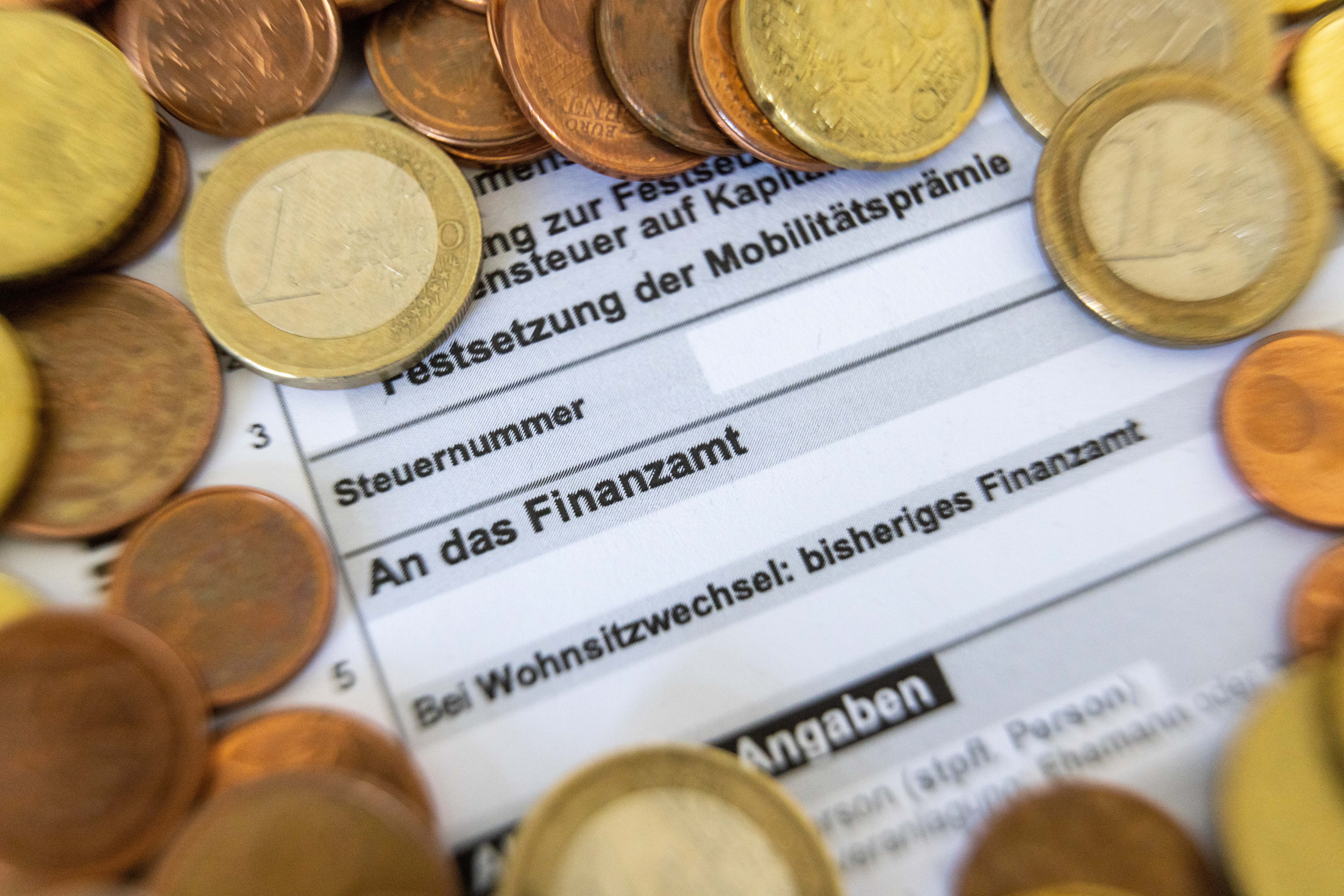 Ein Formular zur Steuererklärung ist von Euro-Münzen bedeckt