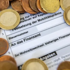 Ein Formular zur Steuererklärung ist von Euro-Münzen bedeckt