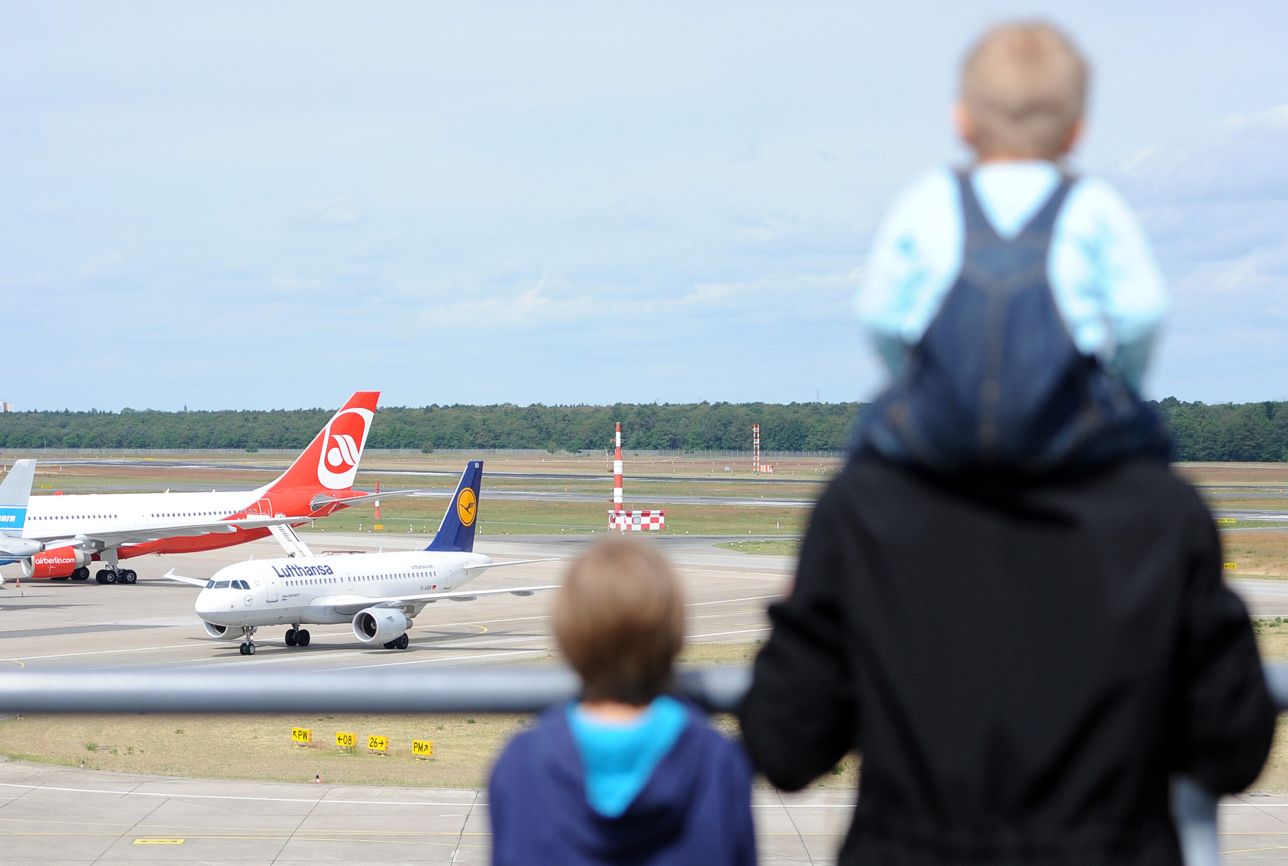 Ein Vater und seine Kinder blicken aufs Flugfeld in Berlin