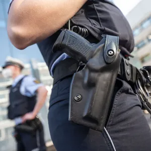 Die Dienstwaffe einer Polizeibeamtin steckt im Holster, Nahaufnahme.
