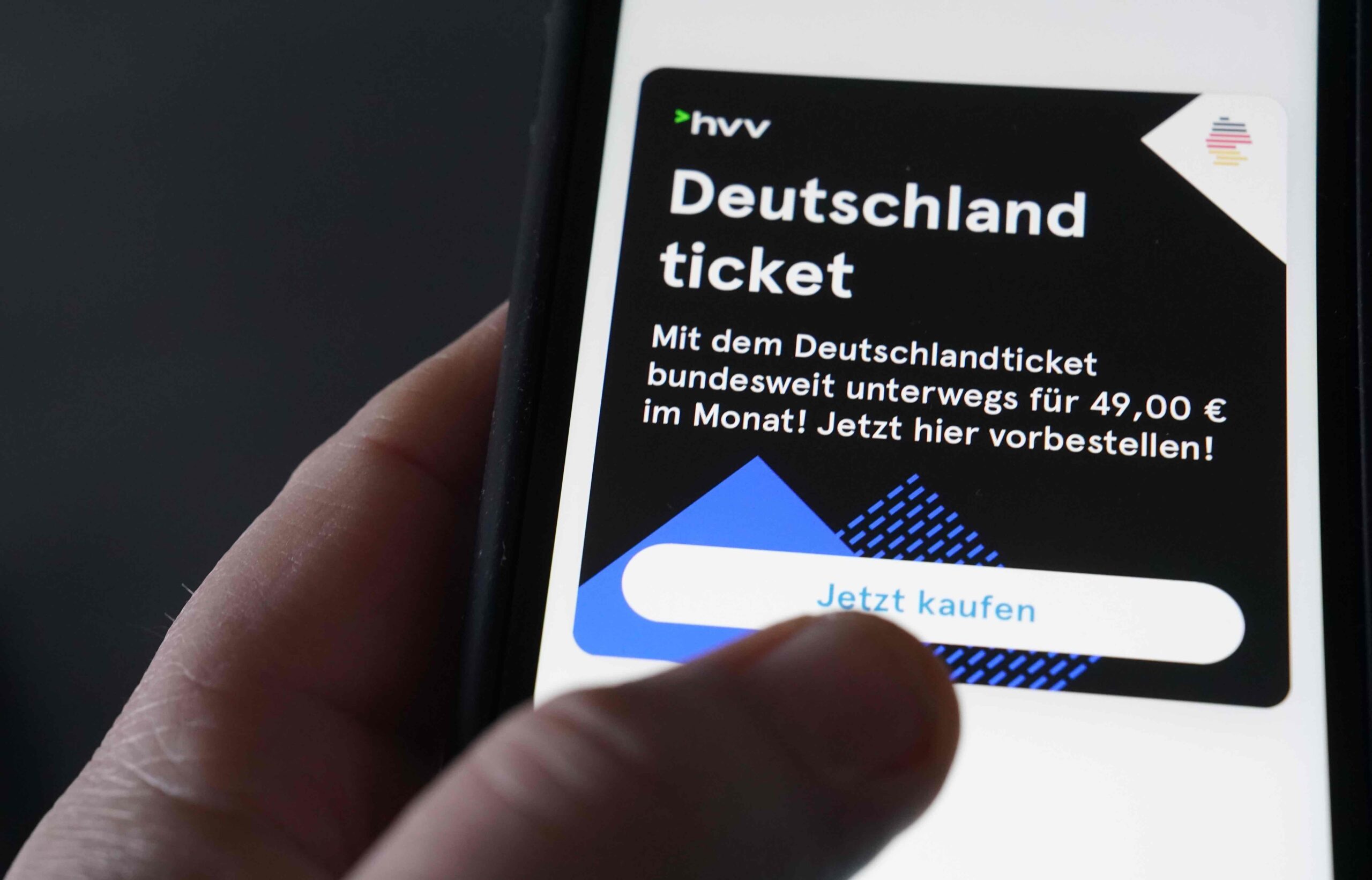 Ein Mann tippt auf seinem Smartphone auf die HVV-Switch-App, um das Deutschlandticket zu kaufen.