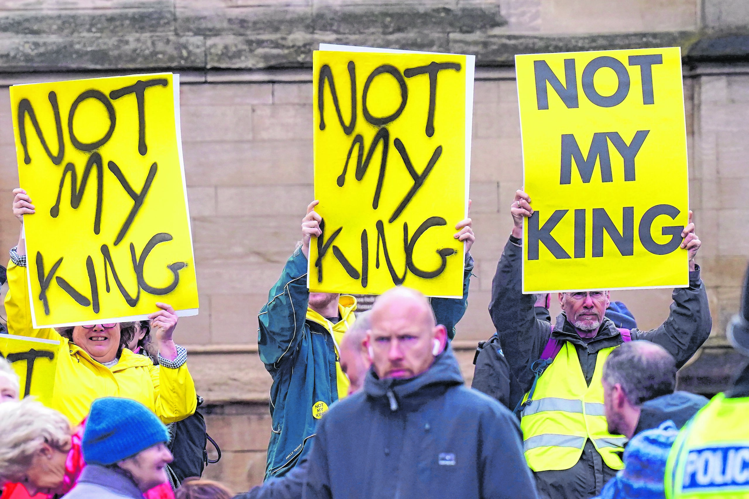 Monarchie-Gegner:innen mit Plakaten mit der Aufschrift „Not My King“ (Dt. Nicht mein König) warten auf Charles III.