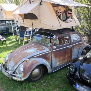 Die Käfer-Fans Philipp und Alina liegen im Zelt auf dem Dach ihres VW-Oldtimers.
