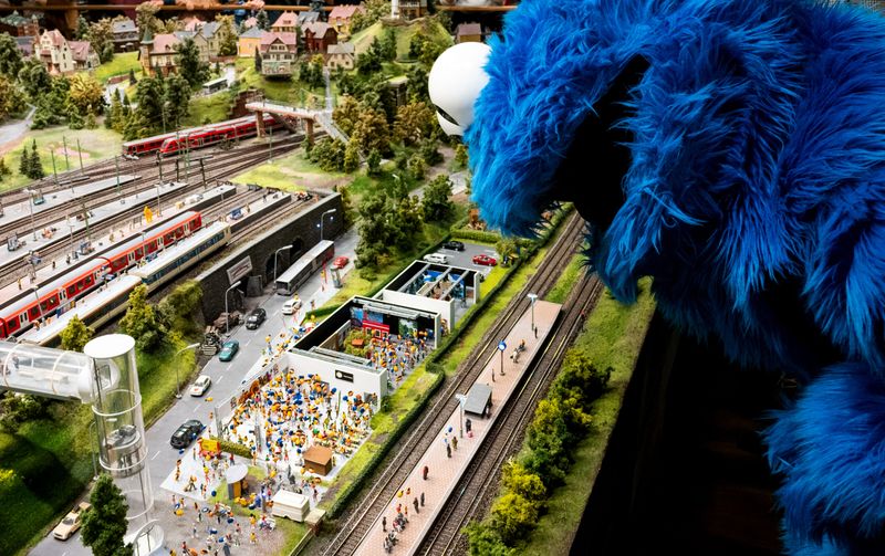 Eine als Krümelmonster verkleidete Person betrachtet eine Sonderausstellung, die zum 50-jährigen Jubiläum der Sesamstraße im Miniaturwunderland aufgebaut ist.