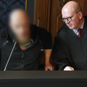 Der Angeklagte (l-r) im Totschlagprozess und Andreas Roter, Rechtsanwalt, nehmen vor dem Prozessauftakt im Saal des Landgerichts Schwerin Platz.