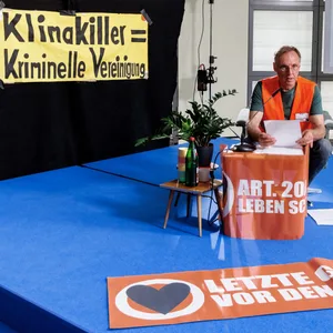 Ein Mann liest im Rahmen einer bundesweiten Kunstperformace der Aktivistengruppe Letzte Generation auf einer Dauerlesung im Foyer der Galerie der Gegenwart der Hamburger Kunsthalle Texte über gewaltfreien Widerstand.