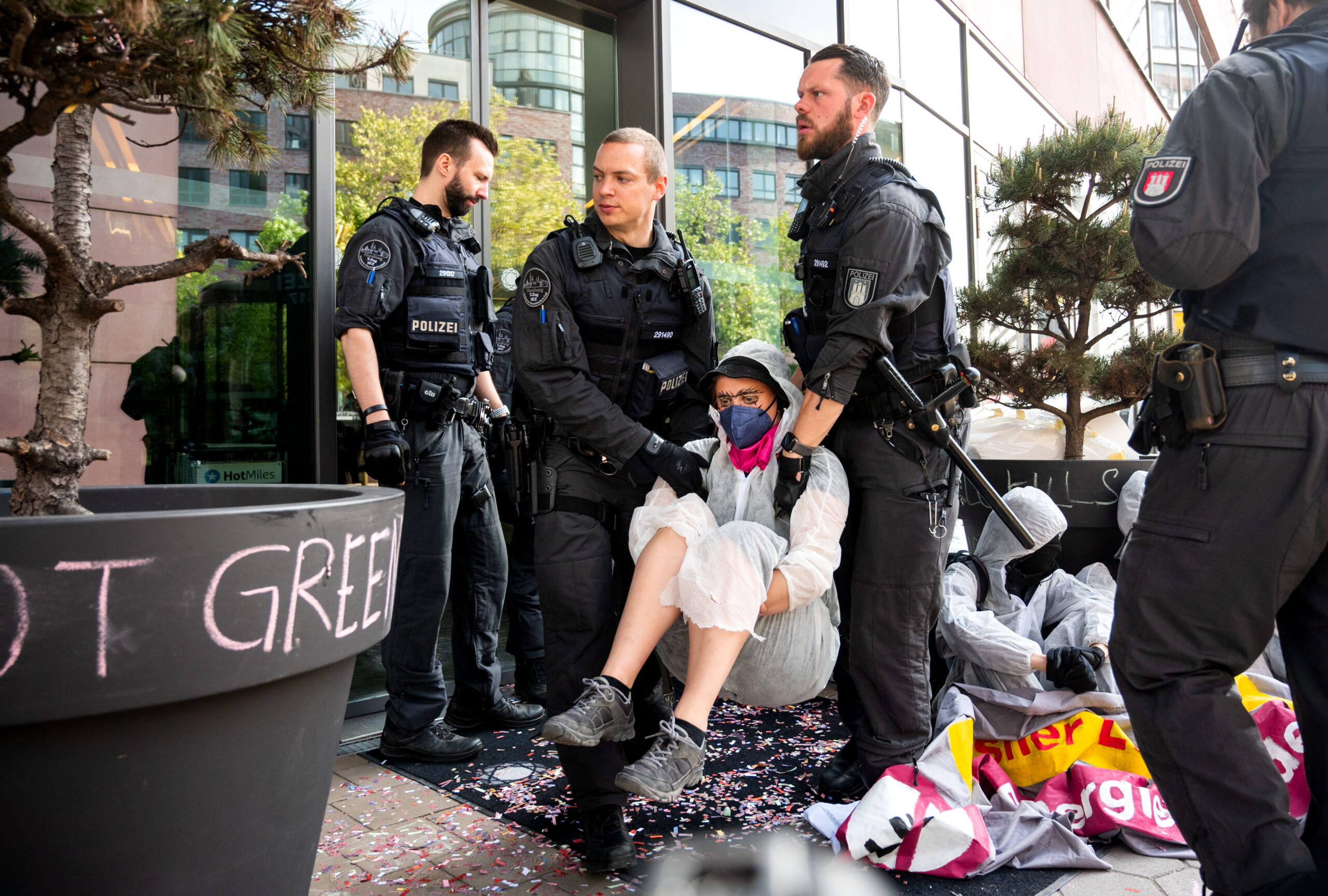 Eine Klimaaktivistin der Gruppe Ende Gelände wird von Polizisten weggetragen. Klimaaktivisten blockierten den Zugang zu einem Hotel, um gegen das 5th Global LNG Forum zu protestieren.