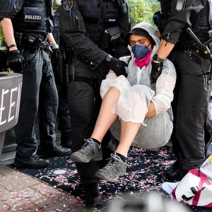Eine Klimaaktivistin der Gruppe Ende Gelände wird von Polizisten weggetragen. Klimaaktivisten blockierten den Zugang zu einem Hotel, um gegen das 5th Global LNG Forum zu protestieren.
