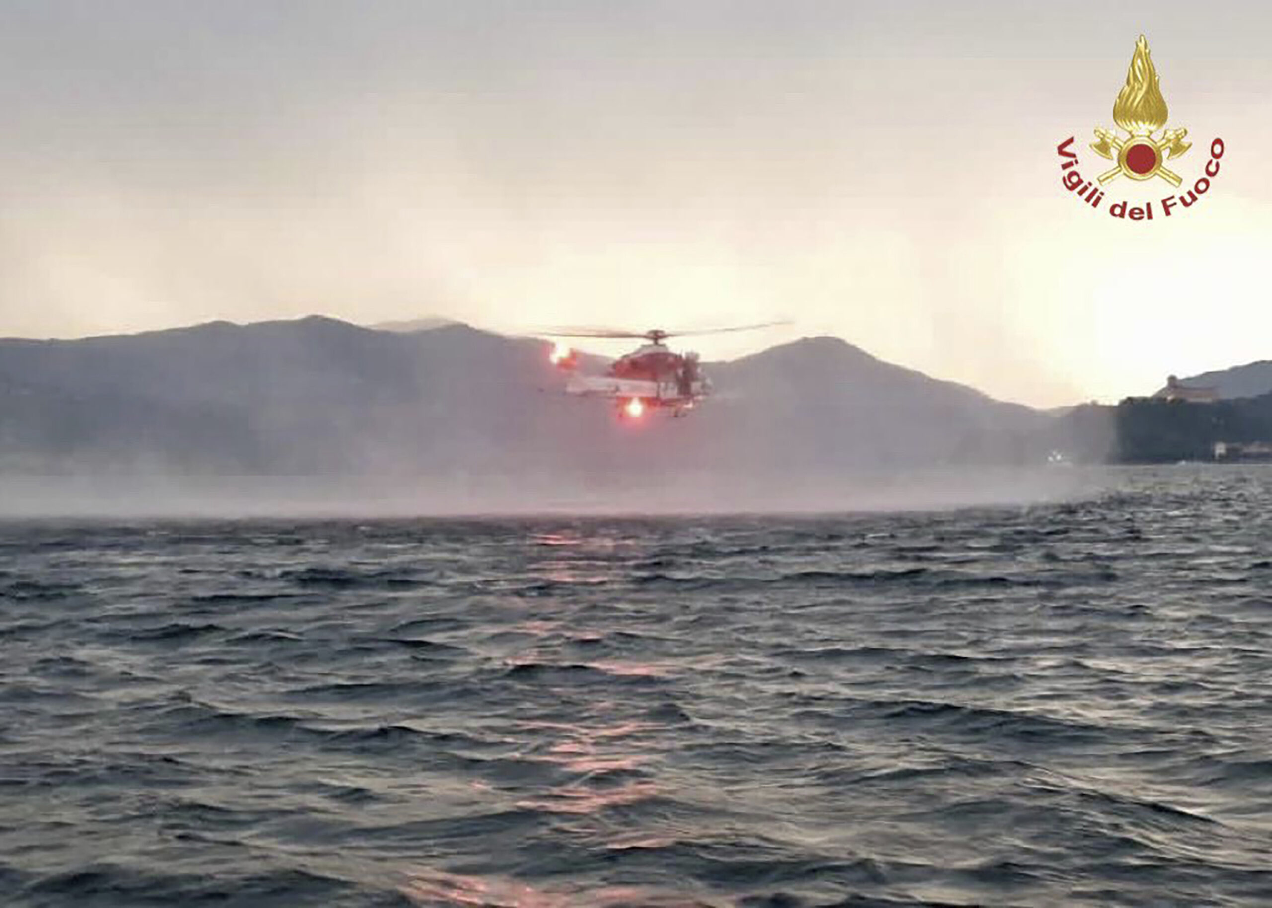 Dieses von der italienischen Feuerwehr veröffentlichten Bild zeigt einen Hubschrauber bei der Suche nach Vermissten, nachdem ein Touristen-Boot in einem Sturm auf dem italienischen Lago Maggiore gekentert ist.