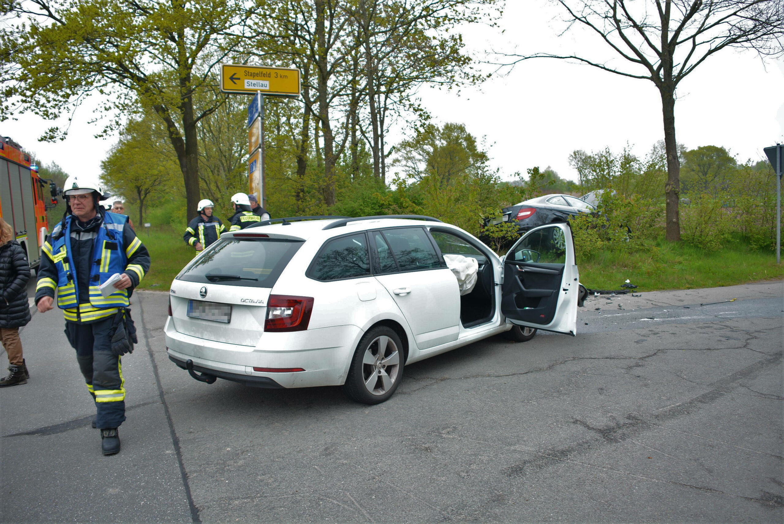 Ein weißer Skoda Kombi steht beschädigt auf der Straße. Im Hintergrund liegt ein schwarzer Mercedes in der Böschung