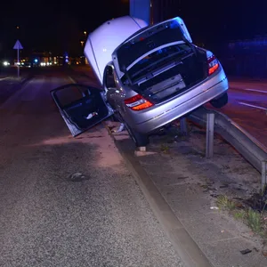 Ein silberfarbener Mercedes steht auf der Leitplanke.