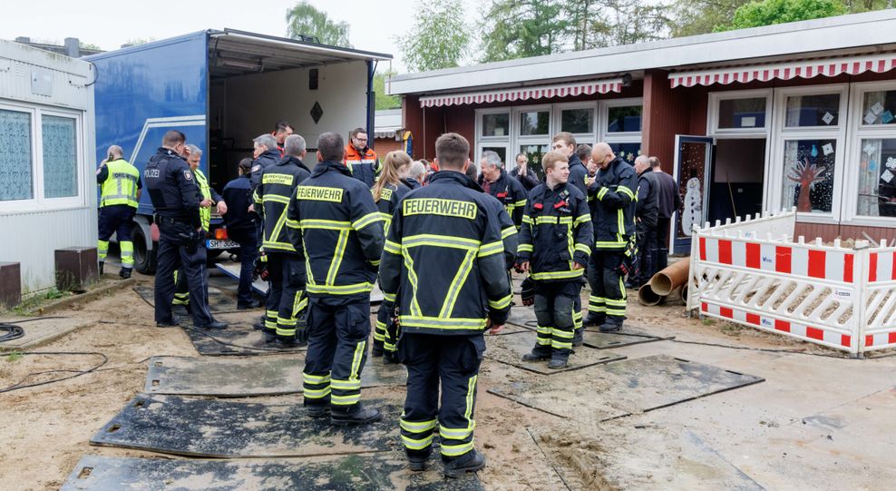 Einsatzkräfte der Feuerwehr stehen vor einer Kita