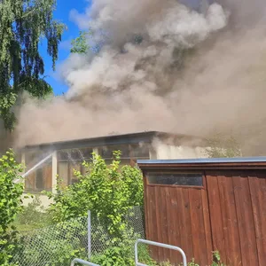 Eine große Rauchwolke steigt von dem brennenden Bungalow in Hausbruch auf.