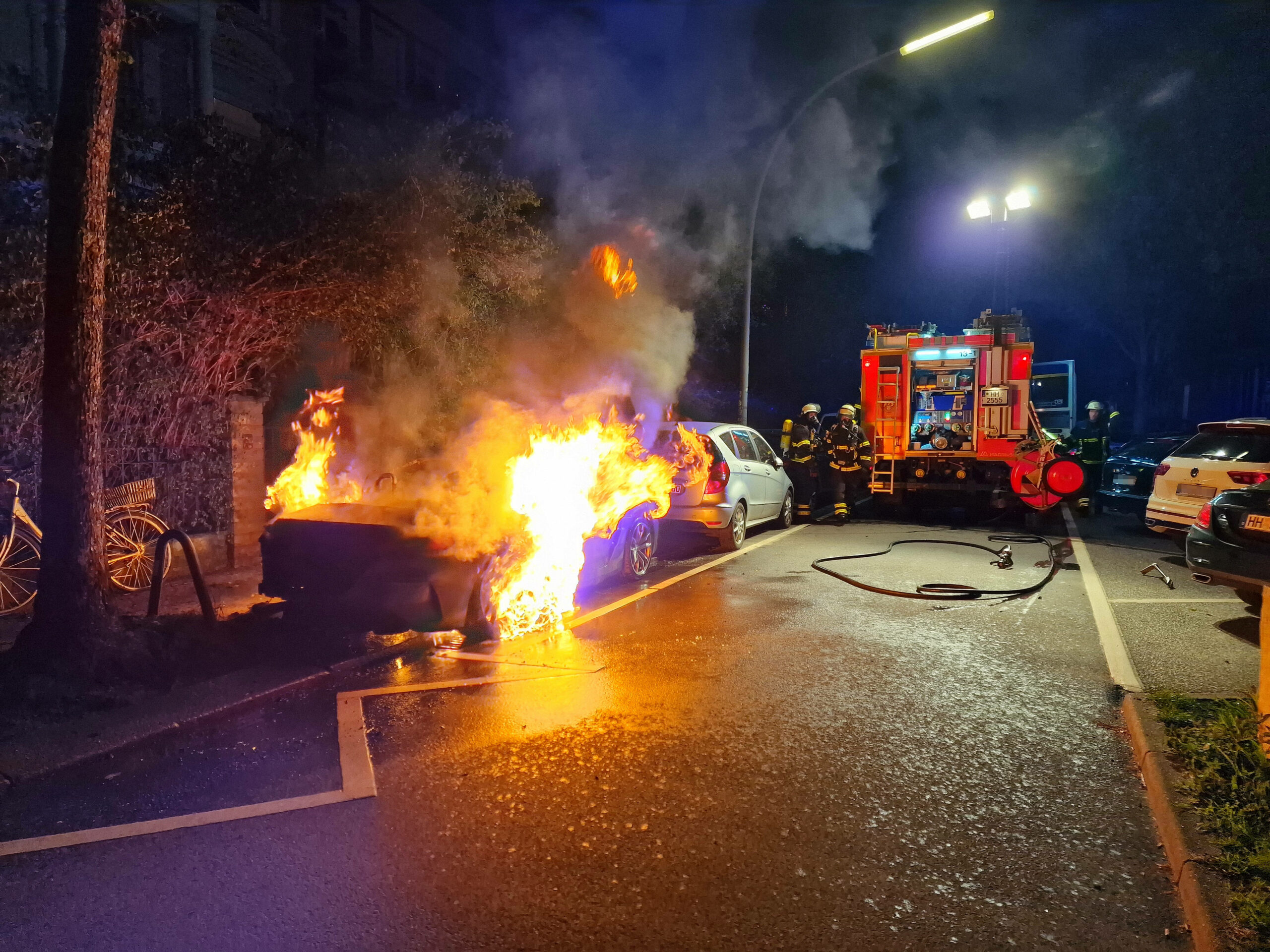Feuerwehr steht neben brennendem BMW Roadster
